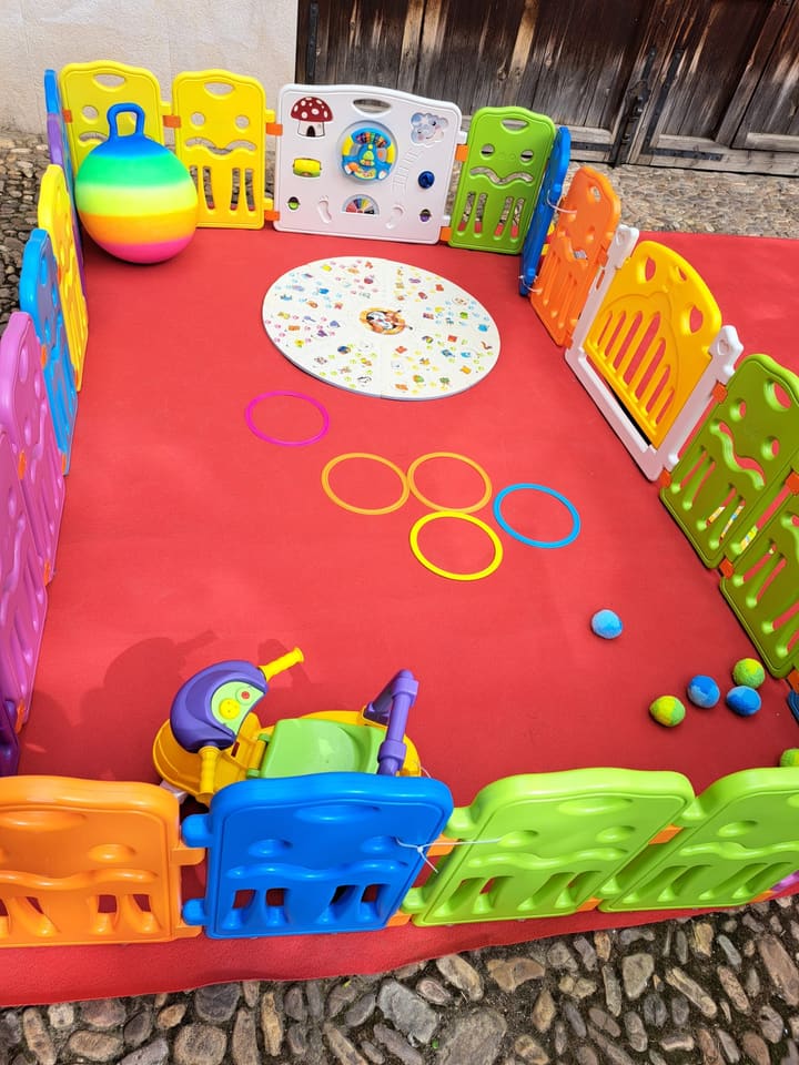 Vista completa del parque al aire libre con juegos y vallas de colores